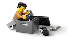 Load image into Gallery viewer, LEGO City Off-Road Mountain Truck minifigure examining treasure from Brick Shack boxed set
