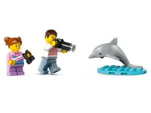 LEGO City sailboat set featuring minifigures with binoculars and camera observing a dolphin on a blue base