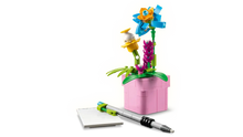 Load image into Gallery viewer, LEGO typewriter set with flowers by Brick Shack featuring a pink flowerpot, blue and yellow flower, and a notepad with pen
