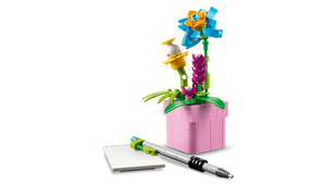 LEGO typewriter set with flowers by Brick Shack featuring a pink flowerpot, blue and yellow flower, and a notepad with pen